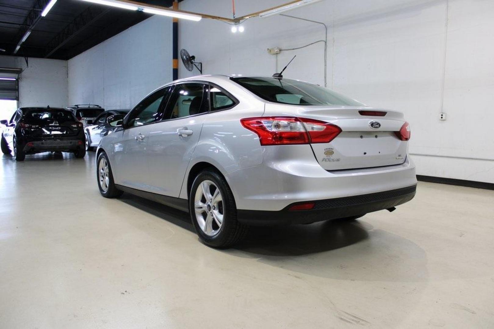 2014 Ingot Silver Metallic /Charcoal/Tangerine Scream Ford Focus SE (1FADP3F28EL) with an I4 engine, Automatic transmission, located at 15300 Midway Rd., Addison, TX, 75001, (972) 702-0011, 32.958321, -96.838074 - HOME OF THE NO HAGGLE PRICE - WHOLESALE PRICES TO THE PUBLIC!! Focus SE, 4D Sedan, I4, FWD, Silver, Charcoal/Tangerine Scream Cloth. Odometer is 60508 miles below market average!<br><br>Silver 2014 Ford Focus SE<br><br>26/36 City/Highway MPG<br><br>Awards:<br> * 2014 IIHS Top Safety Pick * 2014 K - Photo#3