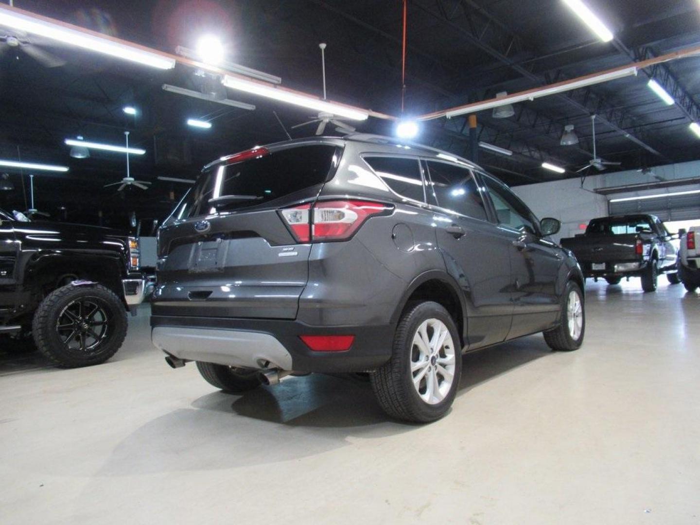 2018 Magnetic /Medium Light Stone Ford Escape SE (1FMCU0GD7JU) with an EcoBoost 1.5L I4 GTDi DOHC Turbocharged VCT engine, Automatic transmission, located at 15300 Midway Rd., Addison, TX, 75001, (972) 702-0011, 32.958321, -96.838074 - HOME OF THE NO HAGGLE PRICE - WHOLESALE PRICES TO THE PUBLIC!! Escape SE, 4D Sport Utility, EcoBoost 1.5L I4 GTDi DOHC Turbocharged VCT, 6-Speed Automatic, FWD, Magnetic, Medium Light Stone Cloth. Odometer is 18027 miles below market average!<br><br>Magnetic 2018 Ford Escape SE<br><br>23/30 City/Hig - Photo#2