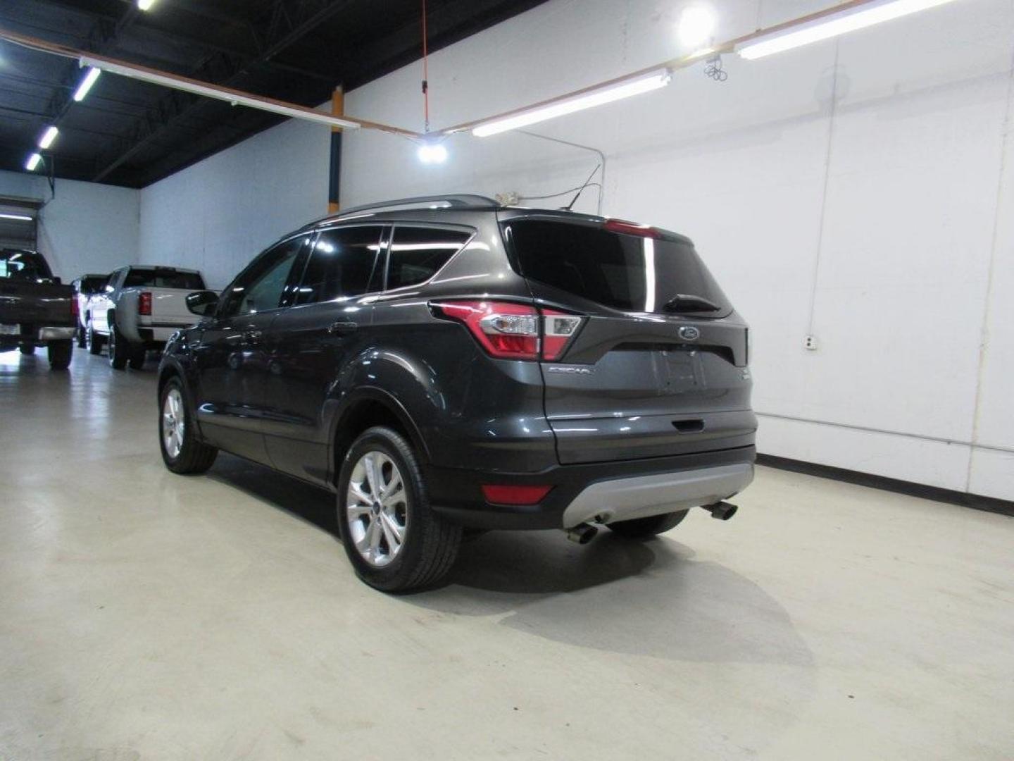 2018 Magnetic /Medium Light Stone Ford Escape SE (1FMCU0GD7JU) with an EcoBoost 1.5L I4 GTDi DOHC Turbocharged VCT engine, Automatic transmission, located at 15300 Midway Rd., Addison, TX, 75001, (972) 702-0011, 32.958321, -96.838074 - HOME OF THE NO HAGGLE PRICE - WHOLESALE PRICES TO THE PUBLIC!! Escape SE, 4D Sport Utility, EcoBoost 1.5L I4 GTDi DOHC Turbocharged VCT, 6-Speed Automatic, FWD, Magnetic, Medium Light Stone Cloth. Odometer is 18027 miles below market average!<br><br>Magnetic 2018 Ford Escape SE<br><br>23/30 City/Hig - Photo#3