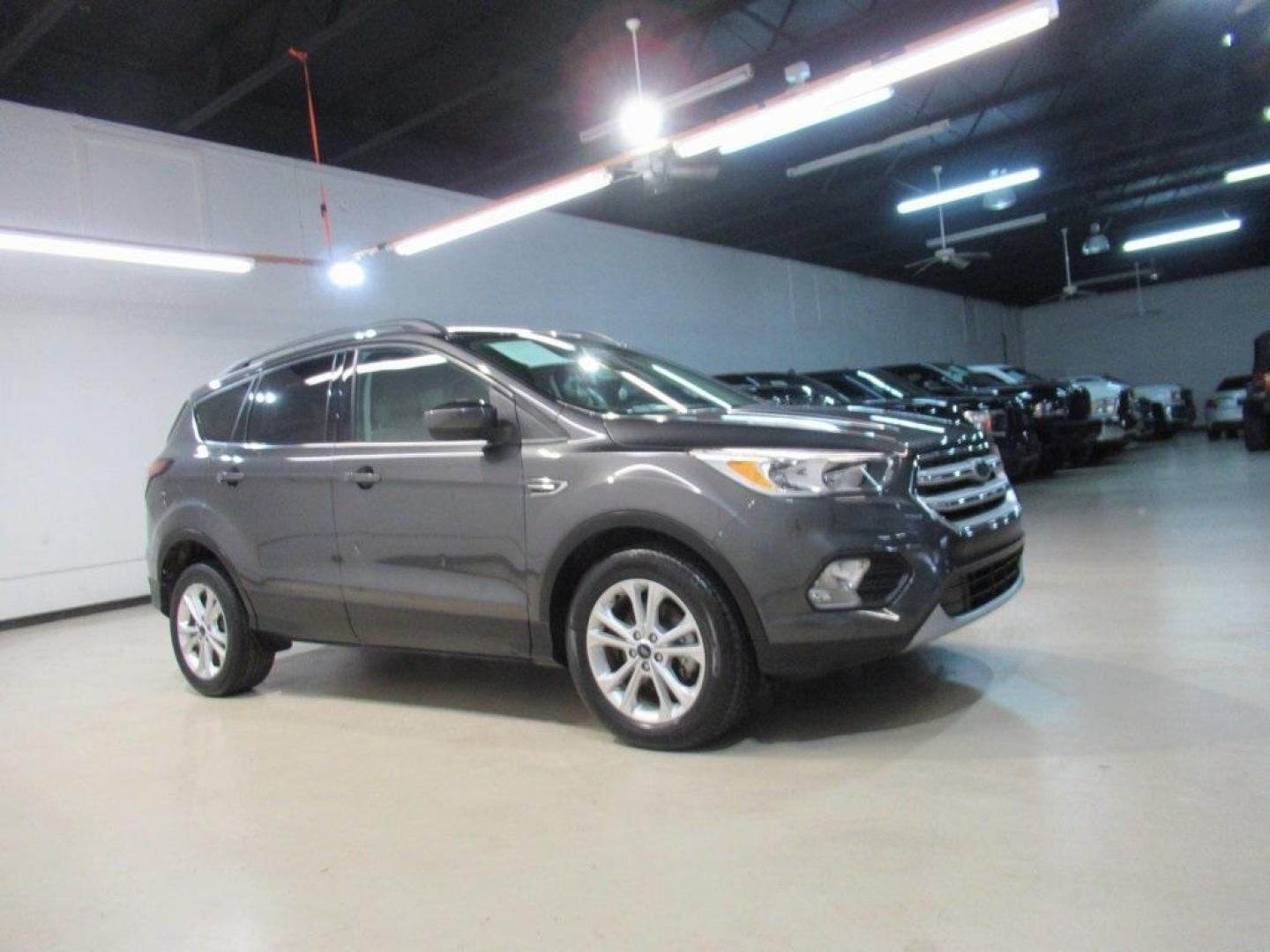 2018 Magnetic /Medium Light Stone Ford Escape SE (1FMCU0GD7JU) with an EcoBoost 1.5L I4 GTDi DOHC Turbocharged VCT engine, Automatic transmission, located at 15300 Midway Rd., Addison, TX, 75001, (972) 702-0011, 32.958321, -96.838074 - HOME OF THE NO HAGGLE PRICE - WHOLESALE PRICES TO THE PUBLIC!! Escape SE, 4D Sport Utility, EcoBoost 1.5L I4 GTDi DOHC Turbocharged VCT, 6-Speed Automatic, FWD, Magnetic, Medium Light Stone Cloth. Odometer is 18027 miles below market average!<br><br>Magnetic 2018 Ford Escape SE<br><br>23/30 City/Hig - Photo#6