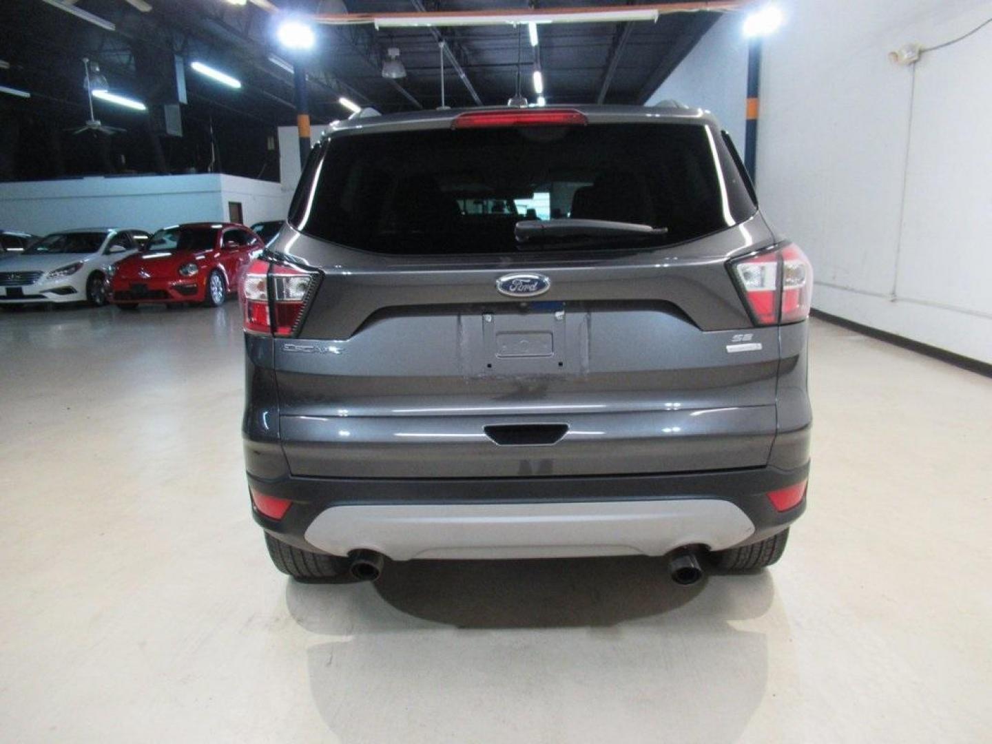 2018 Magnetic /Medium Light Stone Ford Escape SE (1FMCU0GD7JU) with an EcoBoost 1.5L I4 GTDi DOHC Turbocharged VCT engine, Automatic transmission, located at 15300 Midway Rd., Addison, TX, 75001, (972) 702-0011, 32.958321, -96.838074 - HOME OF THE NO HAGGLE PRICE - WHOLESALE PRICES TO THE PUBLIC!! Escape SE, 4D Sport Utility, EcoBoost 1.5L I4 GTDi DOHC Turbocharged VCT, 6-Speed Automatic, FWD, Magnetic, Medium Light Stone Cloth. Odometer is 18027 miles below market average!<br><br>Magnetic 2018 Ford Escape SE<br><br>23/30 City/Hig - Photo#7